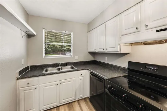 a kitchen with granite countertop white cabinets and appliances