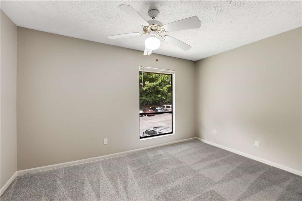 6170 Woodland Road Northwest Peachtree Corners, GA 30092 - Photo 14 of 27 an empty room with windows and chandelier fan