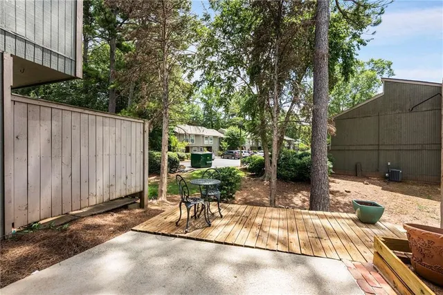 a view of backyard with a table and chairs and wooden fence