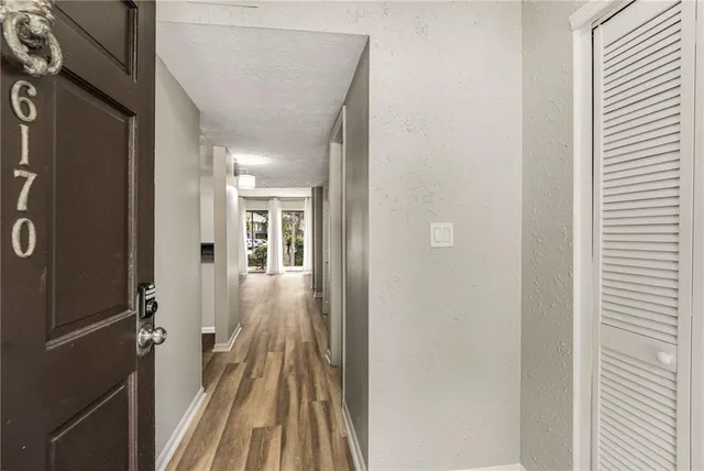 a view of a hallway with wooden floor and staircase