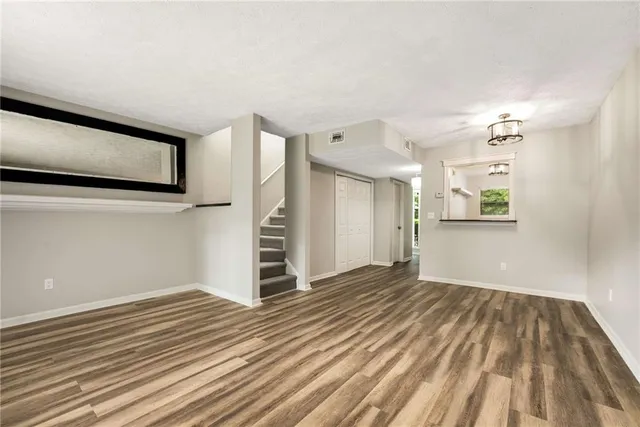 a view of a livingroom with wooden floor and staircase