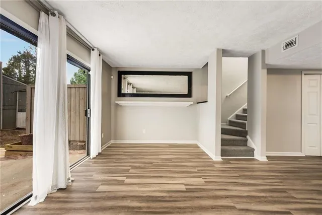 a view of a livingroom with wooden floor and stairs