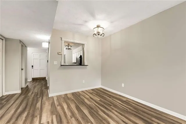 a view of a room with wooden floor and a ceiling fan