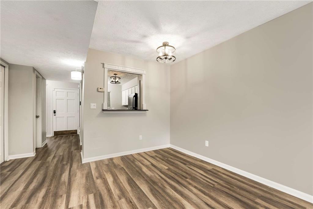 6170 Woodland Road Northwest Peachtree Corners, GA 30092 - Photo 9 of 27 a view of a room with wooden floor and a ceiling fan
