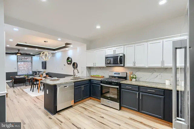 a kitchen with stainless steel appliances granite countertop a stove and cabinets