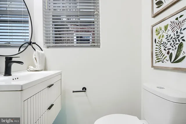a bathroom with a toilet a sink and a window
