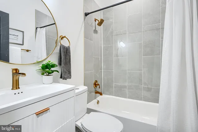 a bathroom with a sink and mirror with bathtub