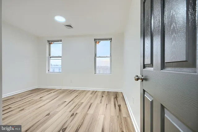 a view of a room with wooden floor and a window