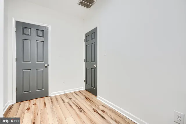 a view of a hallway with wooden floor and closet