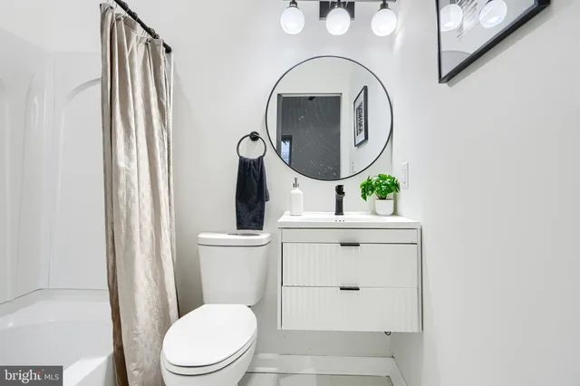a bathroom with a toilet a sink and a mirror