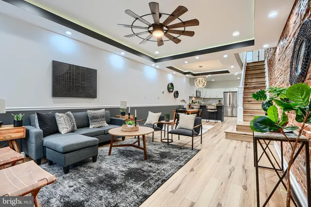 a living room with furniture a chandelier and a rug