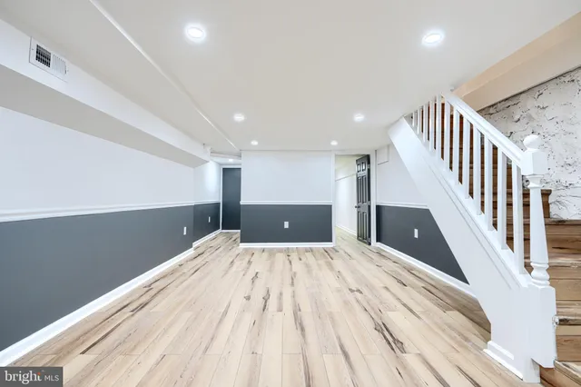 a view of a hallway with wooden floor and staircase