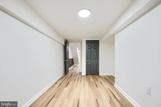 a view of a room with wooden floor and a ceiling fan