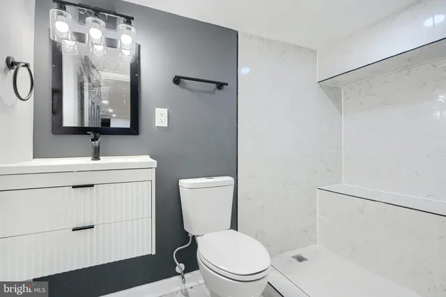 a bathroom with a toilet a sink a mirror and shower