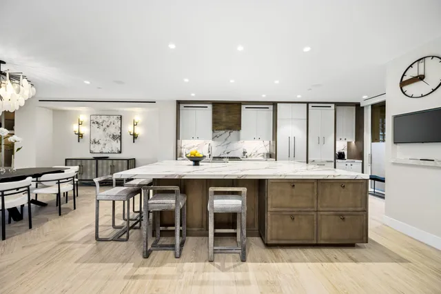 a kitchen with granite countertop a table chairs sink and cabinets