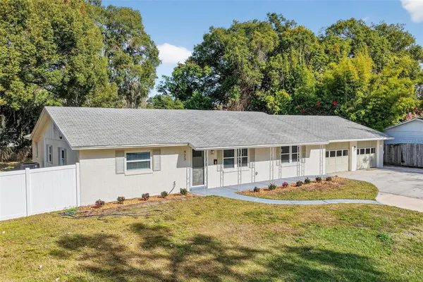 a front view of a house with a yard and trees