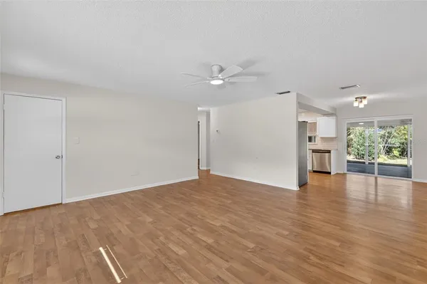 a view of an empty room with a window and wooden floor