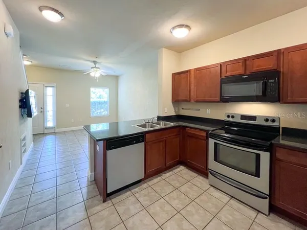 a kitchen with stainless steel appliances granite countertop a stove a sink and a microwave