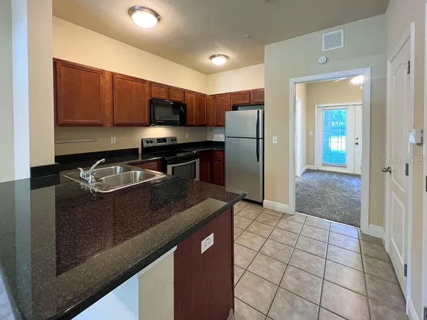 a kitchen with stainless steel appliances granite countertop a stove a refrigerator and a sink