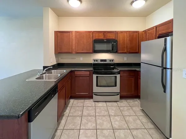 a kitchen with stainless steel appliances granite countertop a stove a refrigerator and a sink