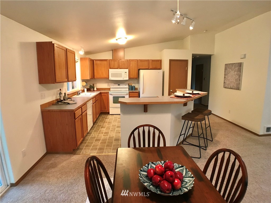 6018 Prather Road Southwest Centralia, WA 98531 - Photo 15 of 28 a kitchen with kitchen island a stove a refrigerator a sink dishwasher with a dining table and chairs