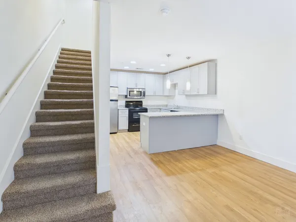 a view of kitchen with wooden floor and electronic appliances