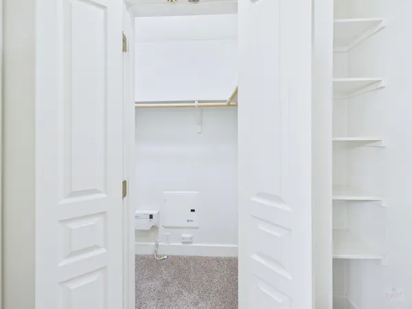 a view of walk in closet with empty racks