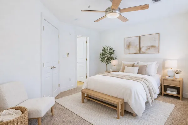 a spacious bedroom with a bed and a chandelier