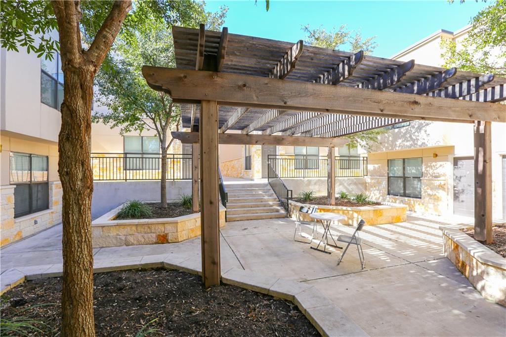 711 West 32nd Street, Unit 114 Austin, TX 78705 - Photo 22 of 23 a view of a patio with a table chairs and a backyard