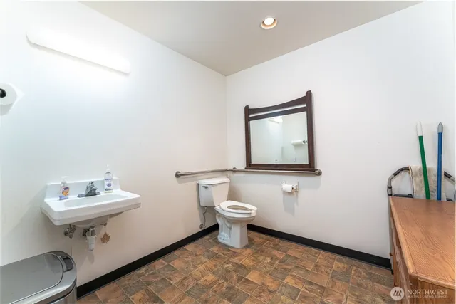a bathroom with a toilet a sink and mirror