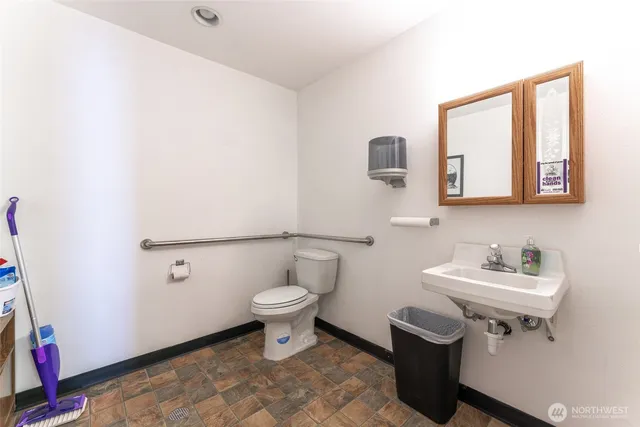 a bathroom with a sink toilet and a mirror