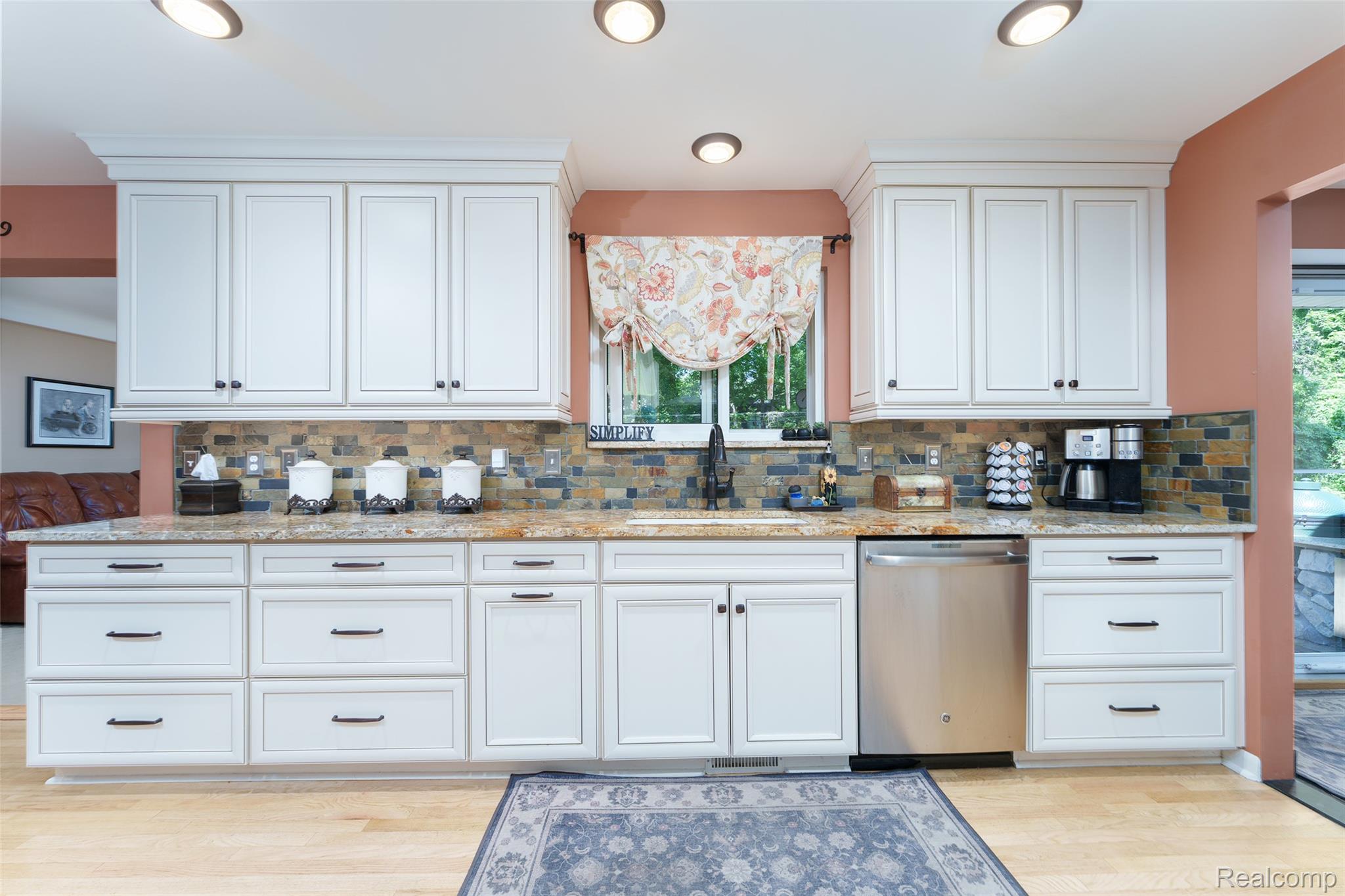 2172 Devonshire Road Bloomfield Hills, MI 48302 - Photo 14 of 45 Kitchen featuring white shaker-style cabinetry, a multi-tone stone tile backsplash, and light-toned wood flooring