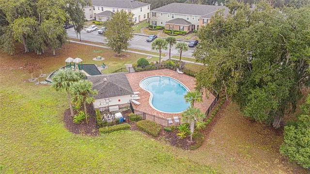 an aerial view of a house with swimming pool and big yard