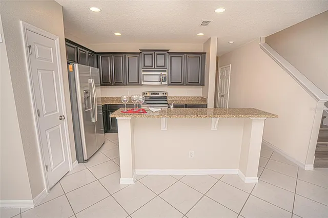 a kitchen with stainless steel appliances granite countertop a refrigerator and a sink