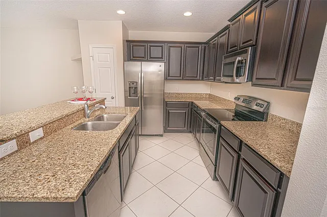a kitchen with stainless steel appliances granite countertop a sink refrigerator and microwave