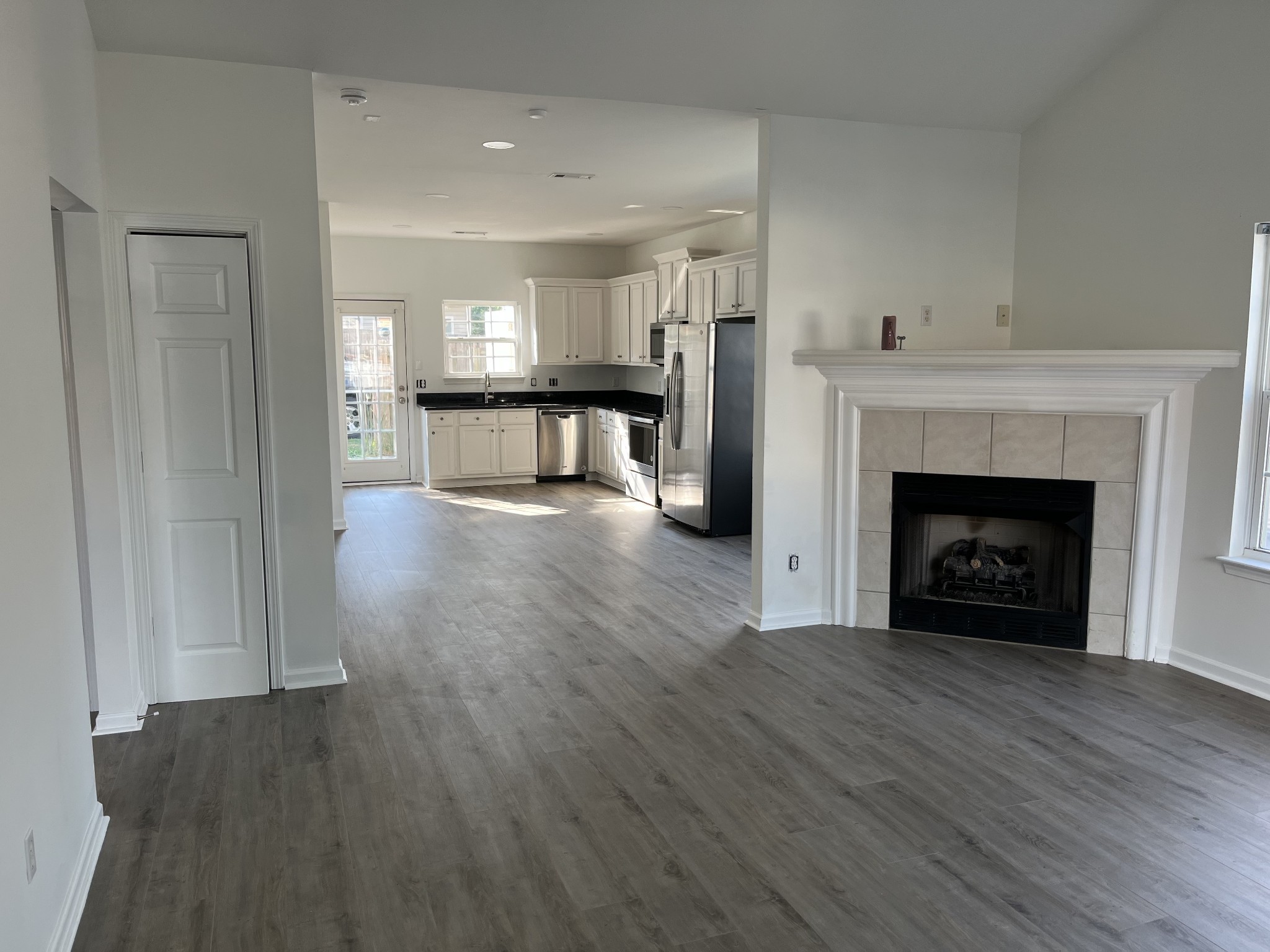 1101 Downs Boulevard, Unit 106 Franklin, TN 37064 - Photo 3 of 11 a view of an empty room with wooden floor fireplace and a window