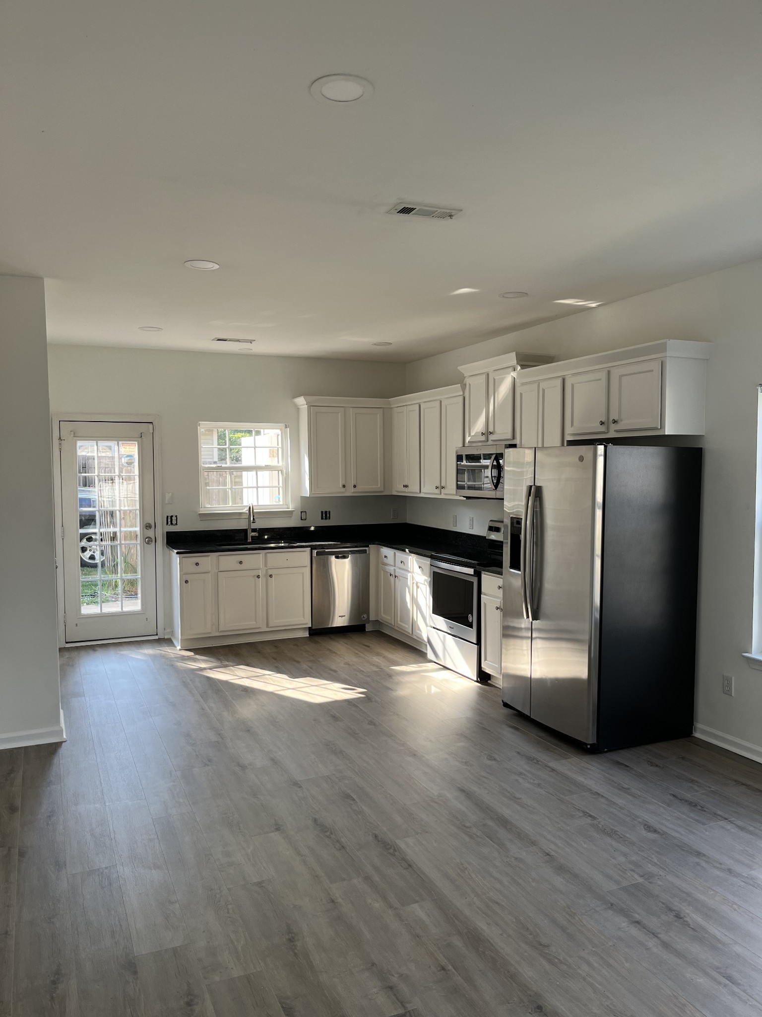 1101 Downs Boulevard, Unit 106 Franklin, TN 37064 - Photo 4 of 11 a view of a kitchen with a sink refrigerator and wooden floor