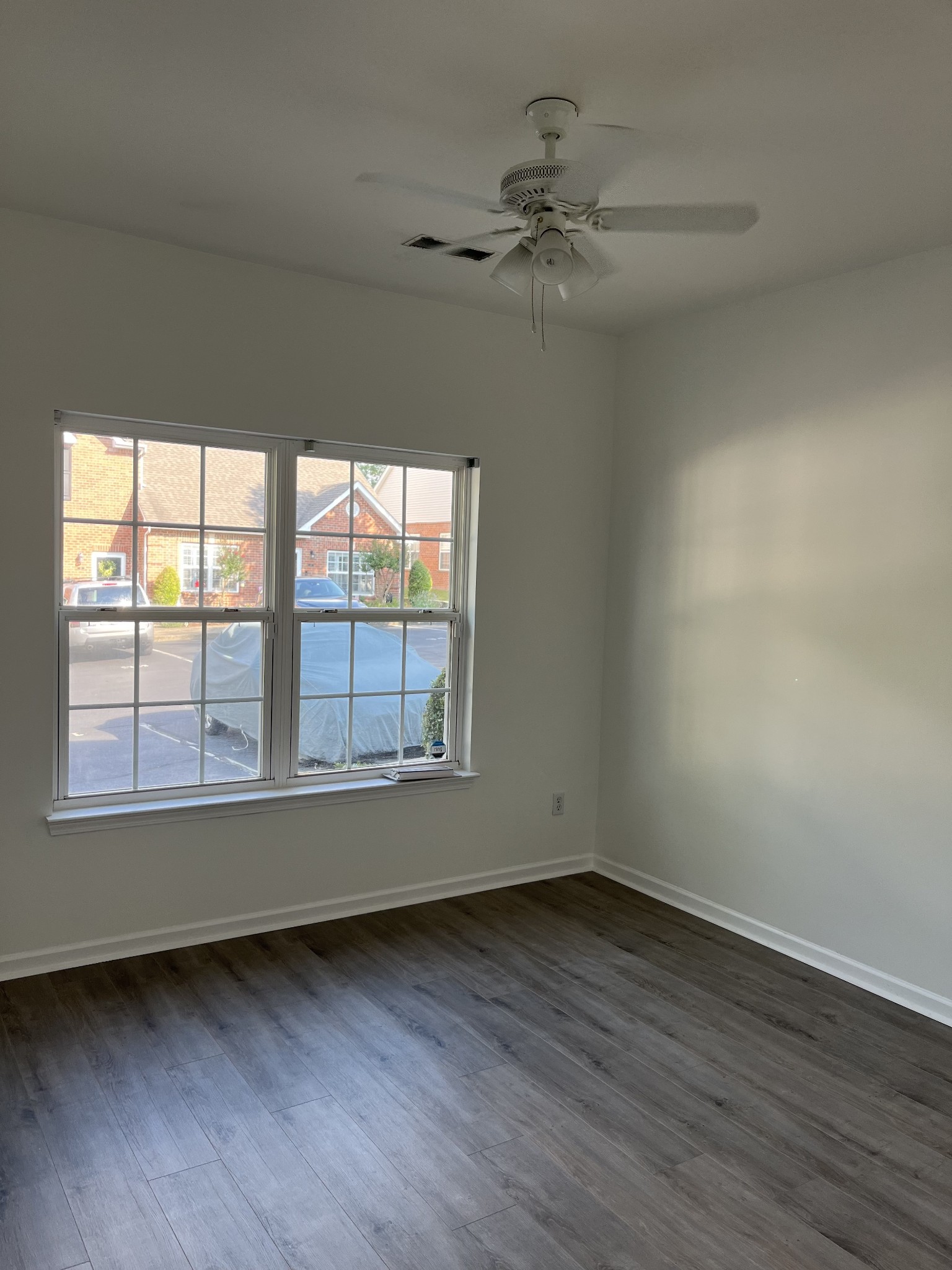 1101 Downs Boulevard, Unit 106 Franklin, TN 37064 - Photo 7 of 11 an empty room with wooden floor fan and windows