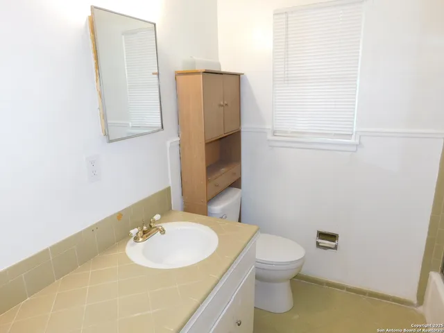 a bathroom with a sink toilet and mirror