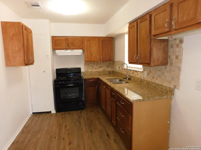 a kitchen with stainless steel appliances granite countertop a refrigerator and a stove