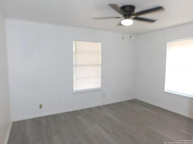 an empty room with a window and a fan