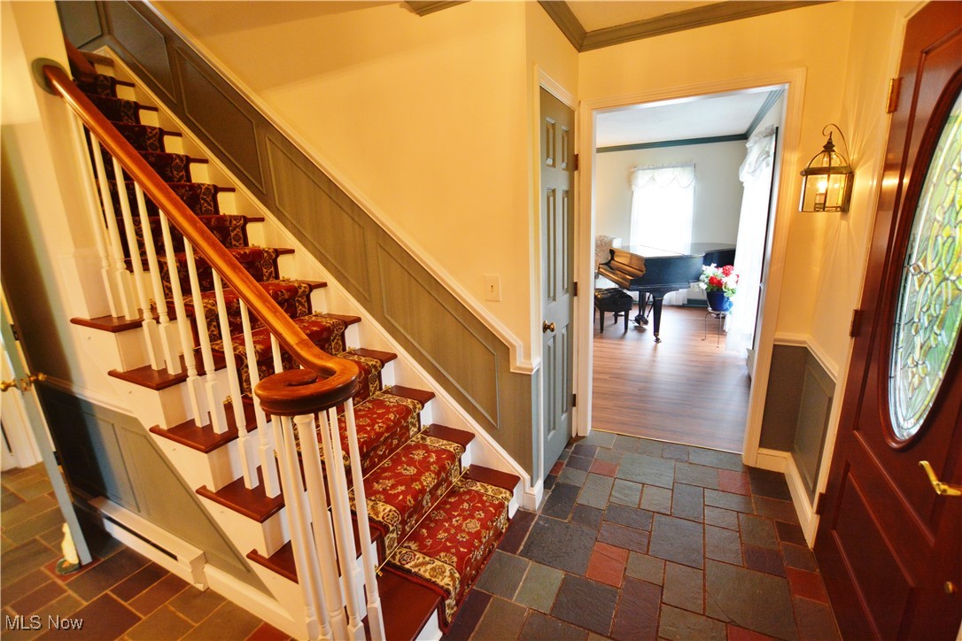 16140 Thompson Road Thompson, OH 44086 - Photo 23 of 50 Staircase with ornamental molding and stone finish floors