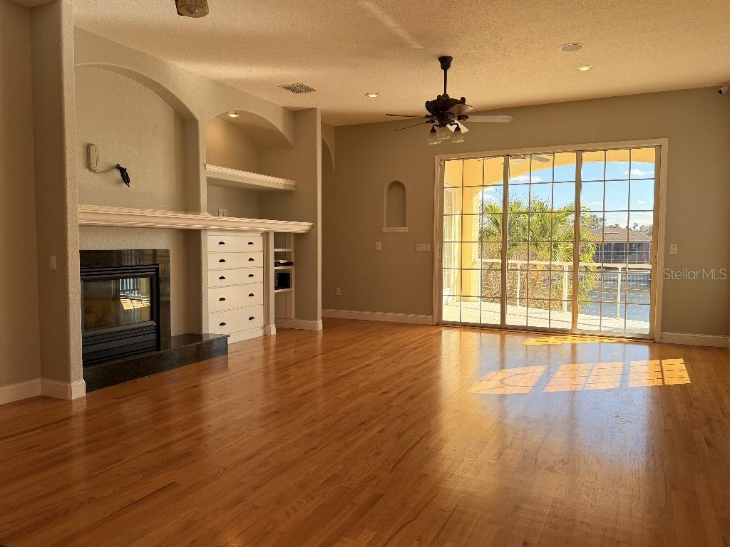 808 Symphony Isles Boulevard Apollo Beach, FL 33572 - Photo 14 of 50 an empty room with wooden floor and windows