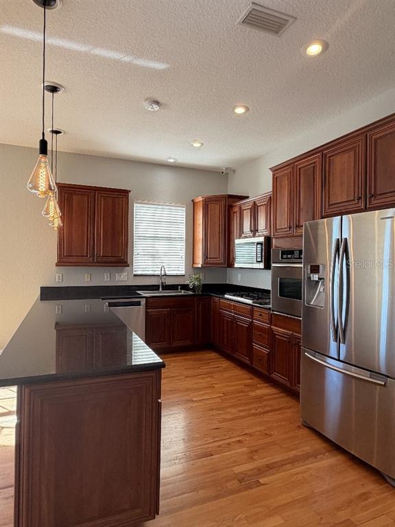808 Symphony Isles Boulevard Apollo Beach, FL 33572 - Photo 20 of 50 a kitchen with granite countertop a refrigerator stove top oven and sink