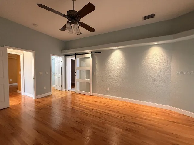 a view of empty room with wooden floor