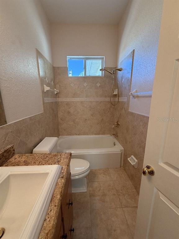 808 Symphony Isles Boulevard Apollo Beach, FL 33572 - Photo 41 of 50 a bathroom with a granite countertop sink a toilet and bathtub