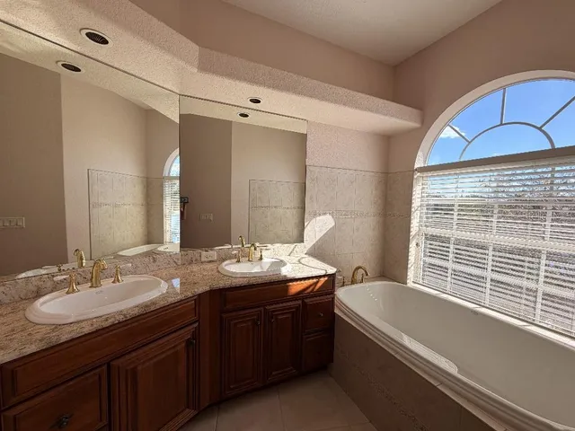 a kitchen with a sink a refrigerator a window and cabinets