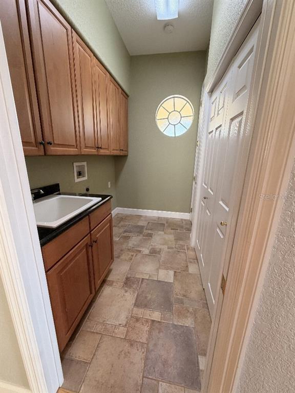 808 Symphony Isles Boulevard Apollo Beach, FL 33572 - Photo 46 of 50 a kitchen with a sink a refrigerator a window and cabinets