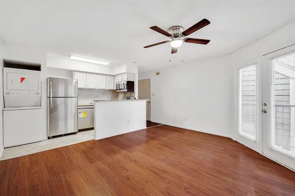 a view of a kitchen with a refrigerator a ceiling fan and wooden floor