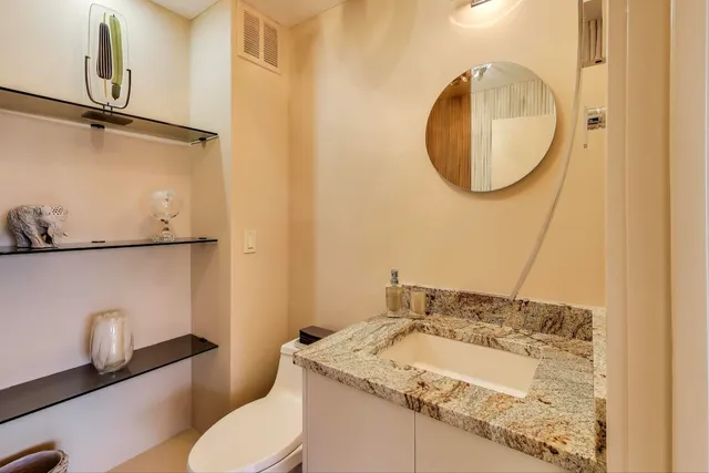 a bathroom with a granite countertop sink a mirror and a shower